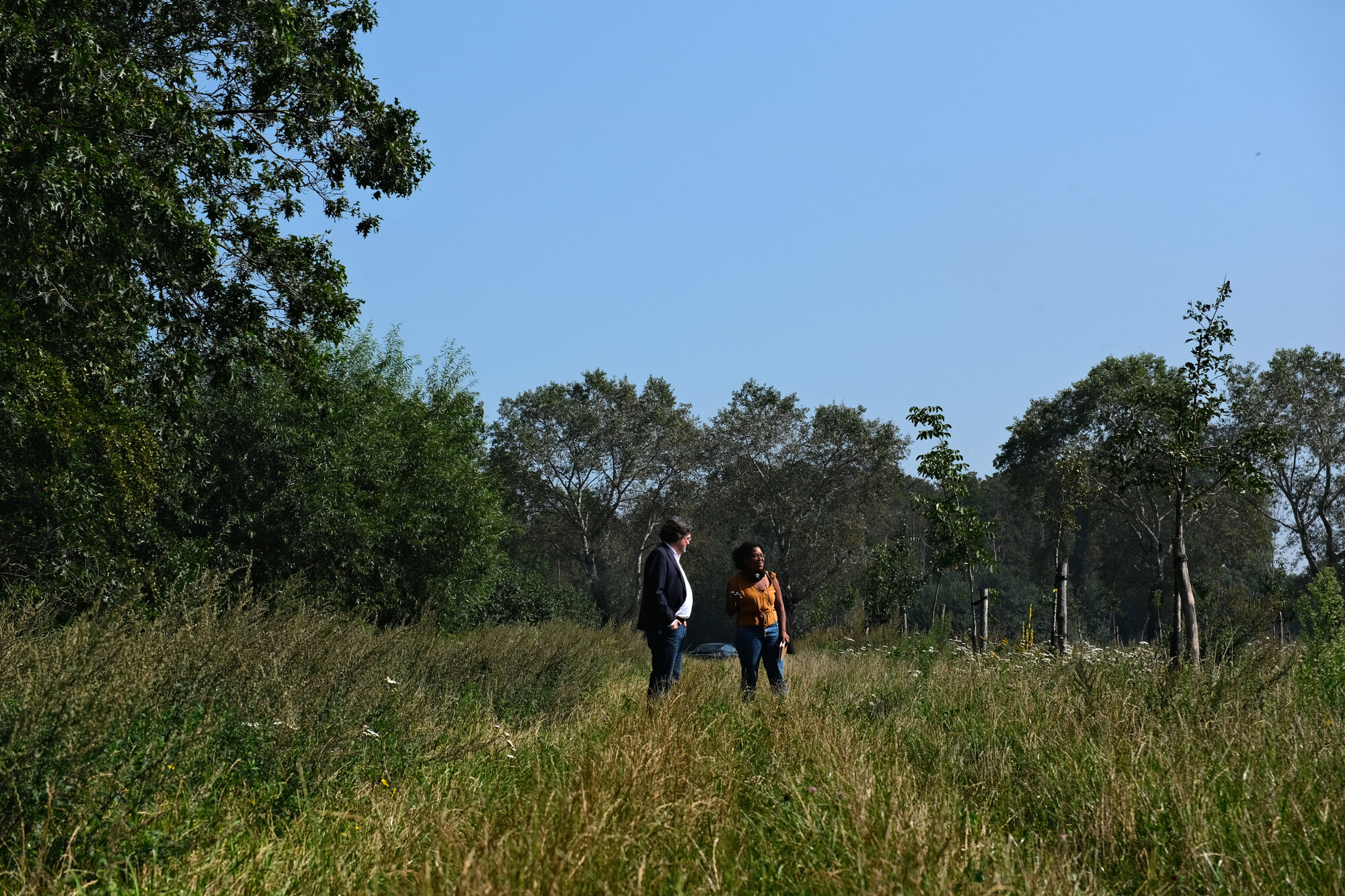 Ton en Oglaya staan in een veld bij het gekapte Sterrebos